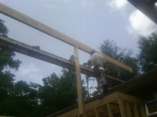 Carpenter setting a ridge beam over a new addition frame — Ice Dam Removal by Roofing Brothers in College Place