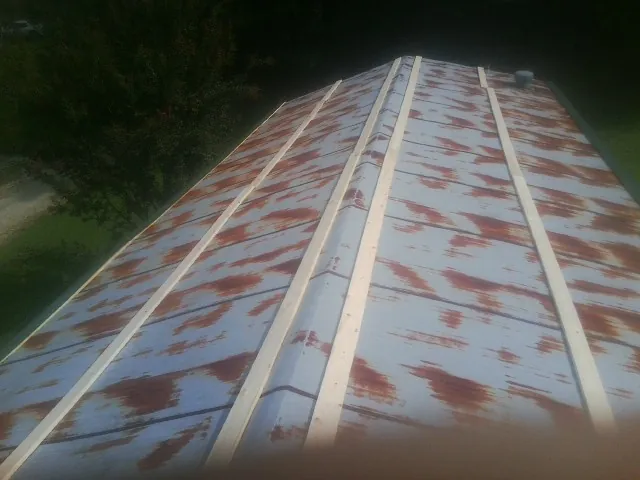Rusted metal roof panels with new wood purlins before replacement — Storm Damage Roof Repair in College Place by Roofing Brothers